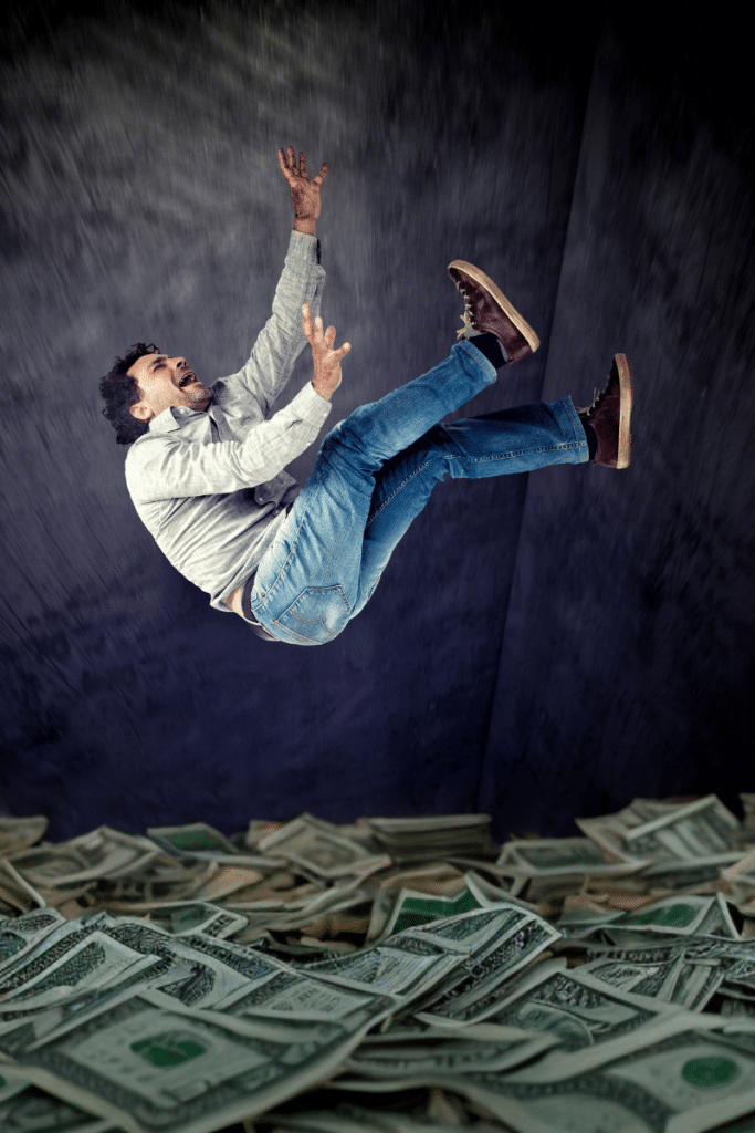 man falling into a financial money pit